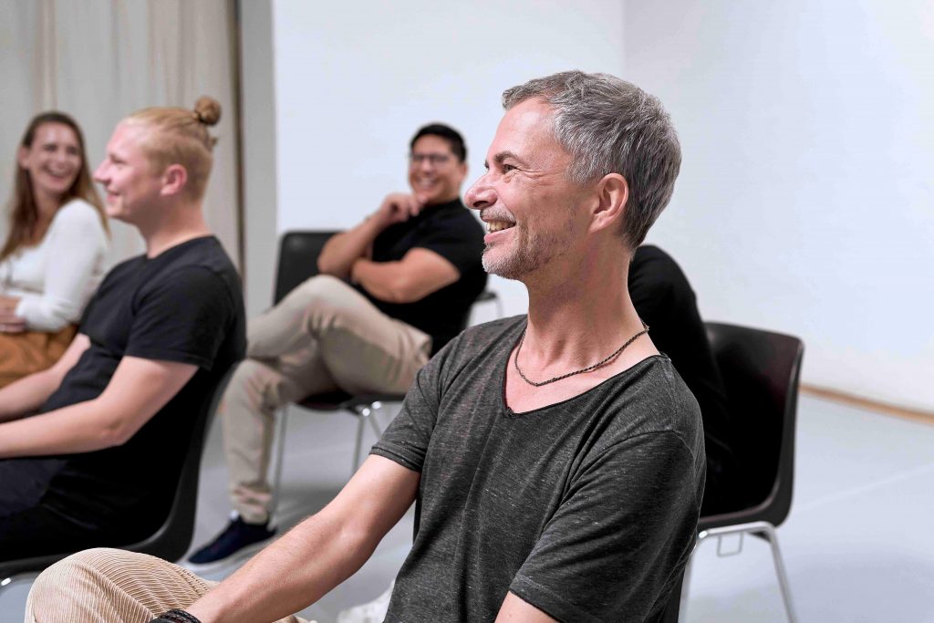 Impro Workshop Unternehmen München – Teilnehmende lachen bei interaktiver Teamübung